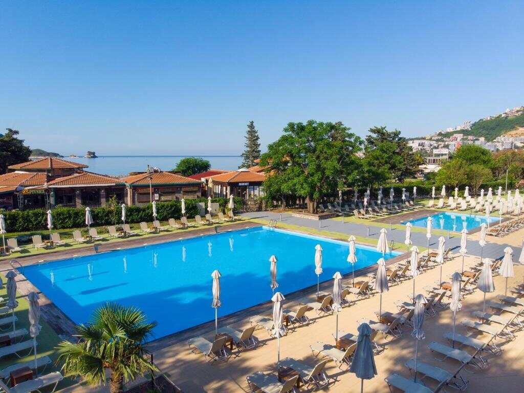 Outdoor saltwater pool with sun loungers and umbrellas